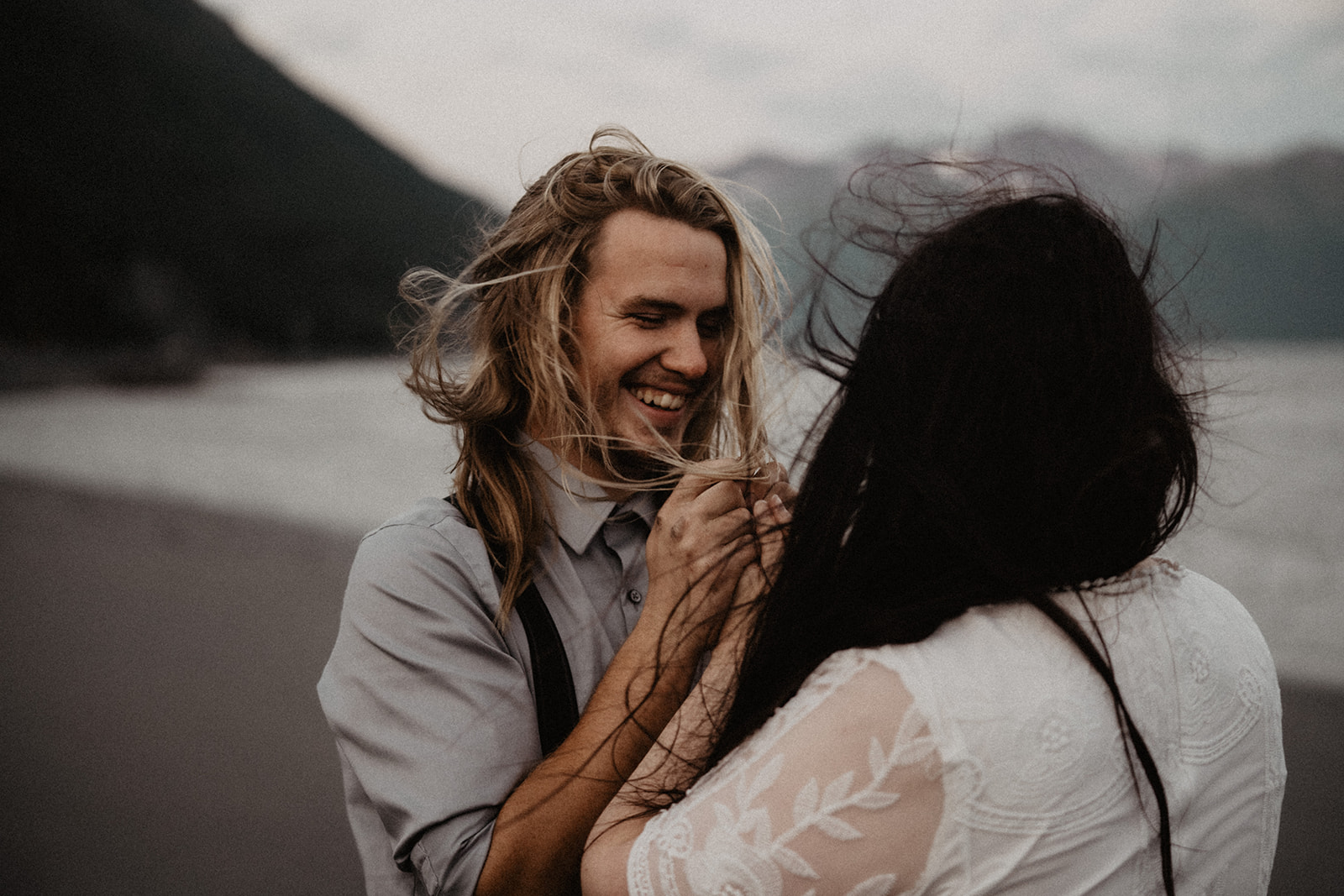 Alaska Elopement with groom holding brides hands in his as he looks into her eyes in the mountains during their first look.