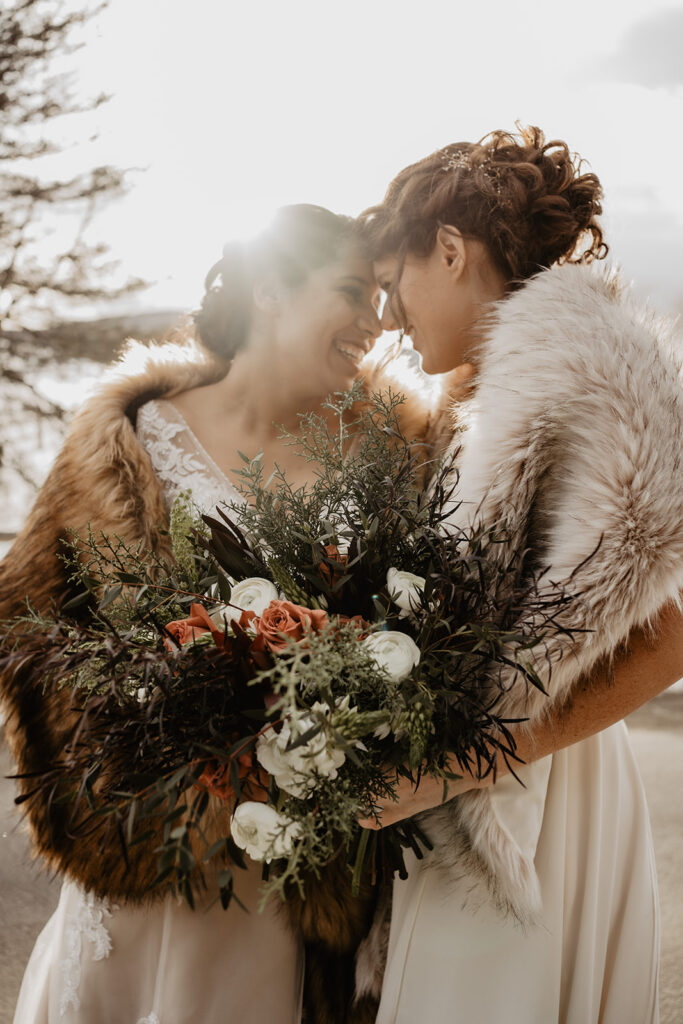 Brides gaze at each other and embrace during their New England Elopement.