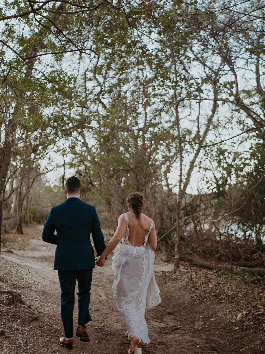 Bride and groom walk on a forest trail during their wedding Costa Rica. 