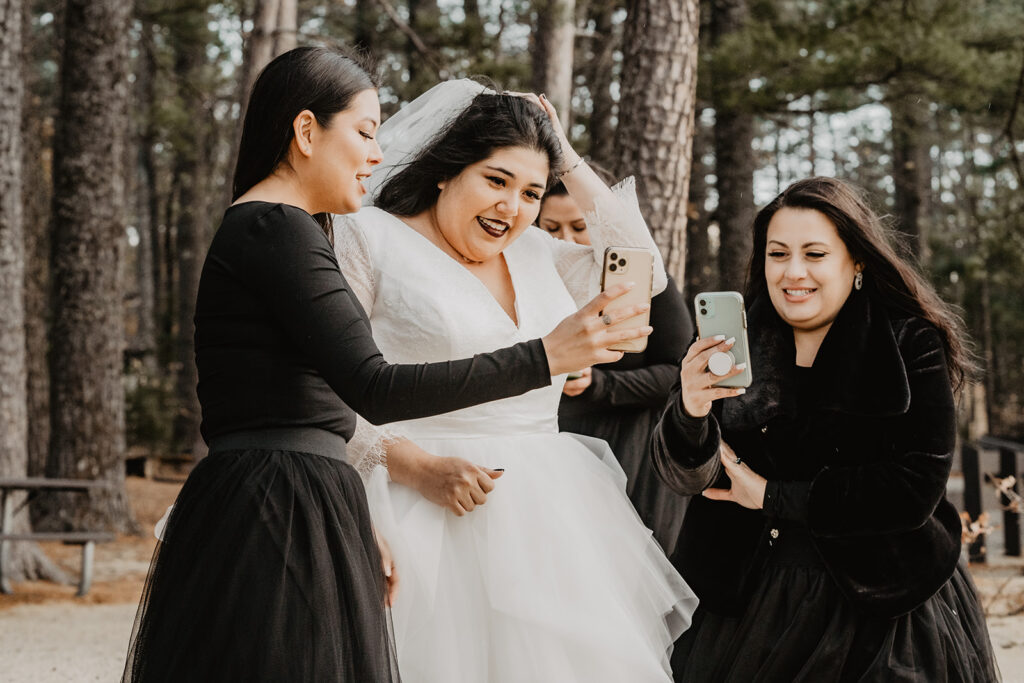 Bride with close friends and family facetime loved ones who could not join them at the elopement. 