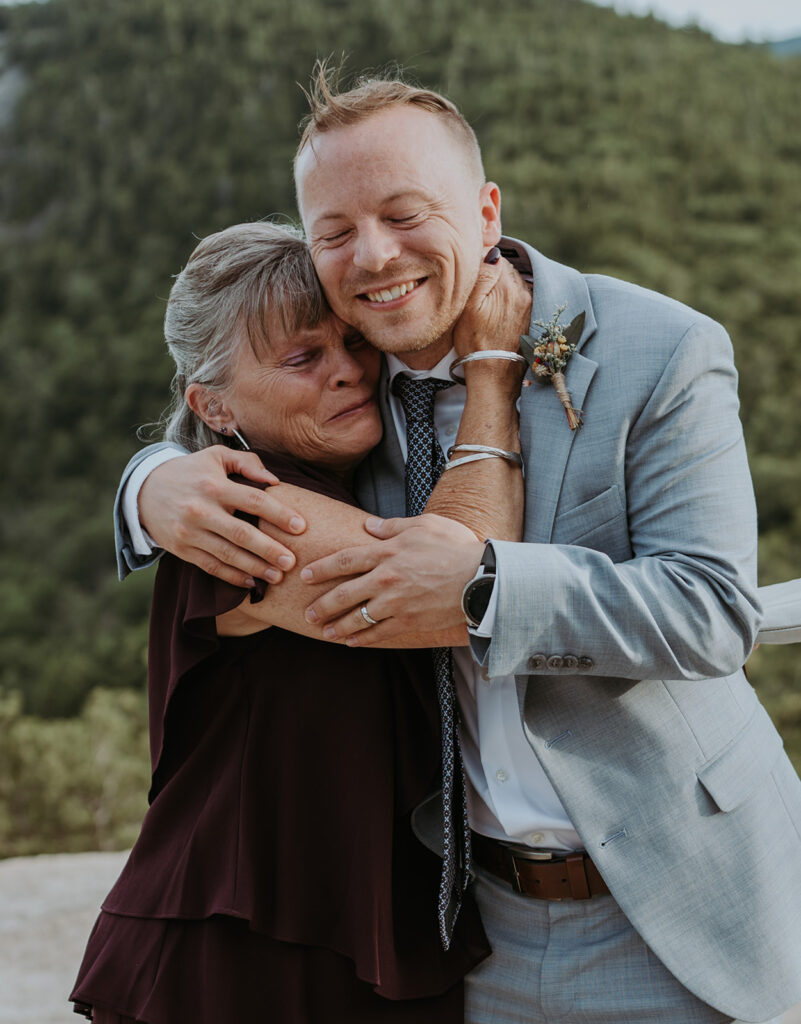 Mom hugging groom after his elopement day at cathedral ledge in new hampshire 